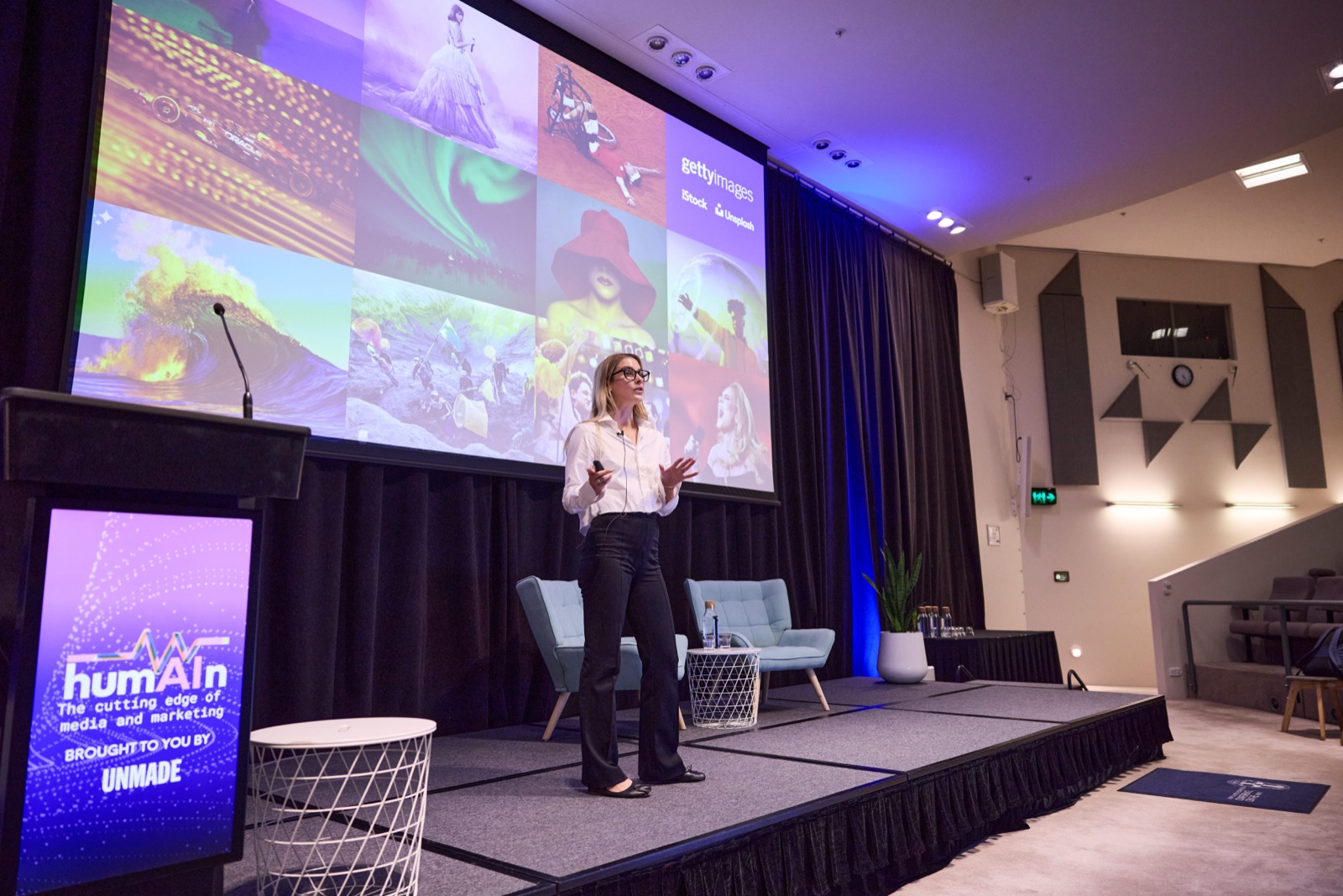 Speaker presenting on stage with a Getty Images AI-generated imagery slide on the screen