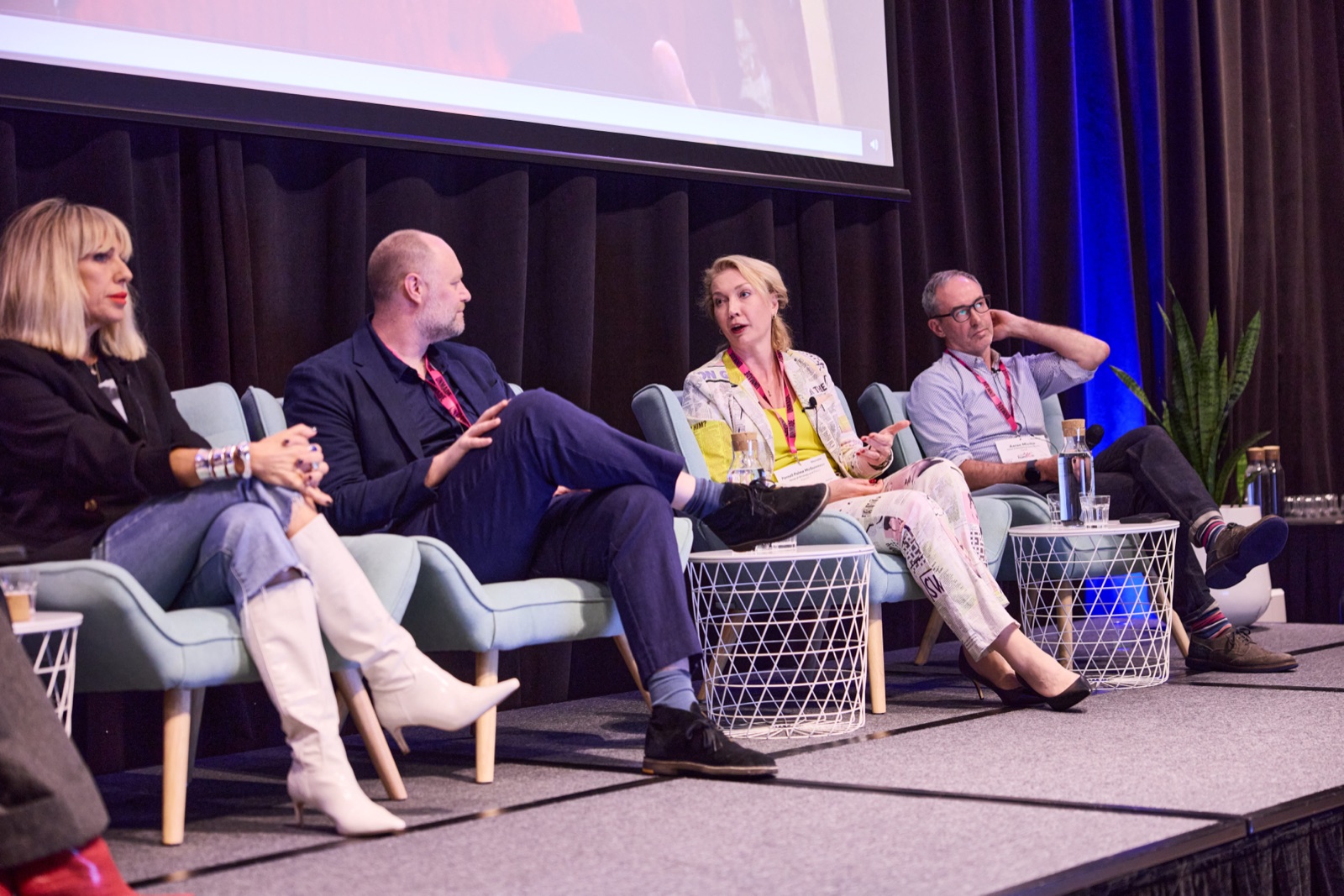 Four panellists in an animated discussion on stage