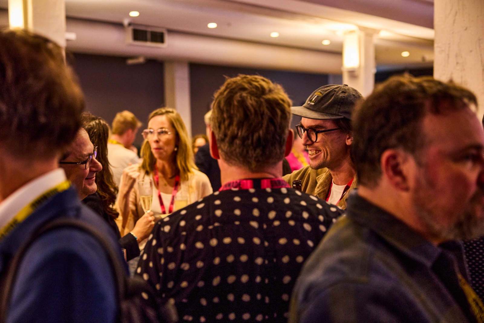 Groups of delegates mingling and laughing during the post-event networking