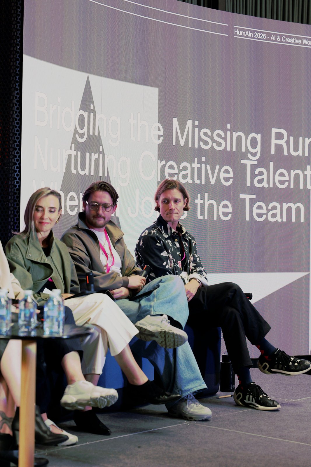 Three panellists seated on stage in front of a slide about nurturing creative talent