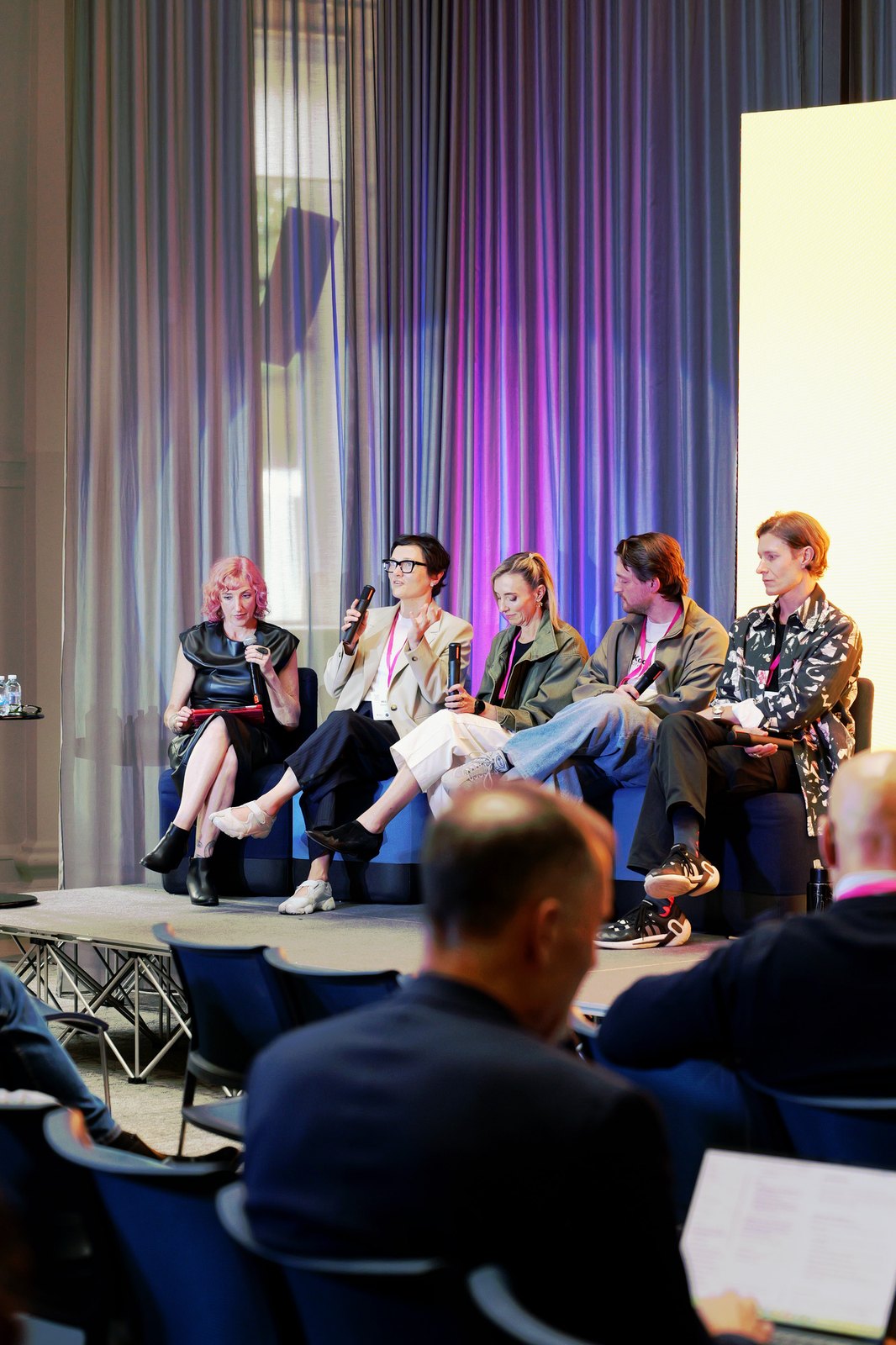 Cat McGinn and a panel seen from the side, with audience members in the foreground