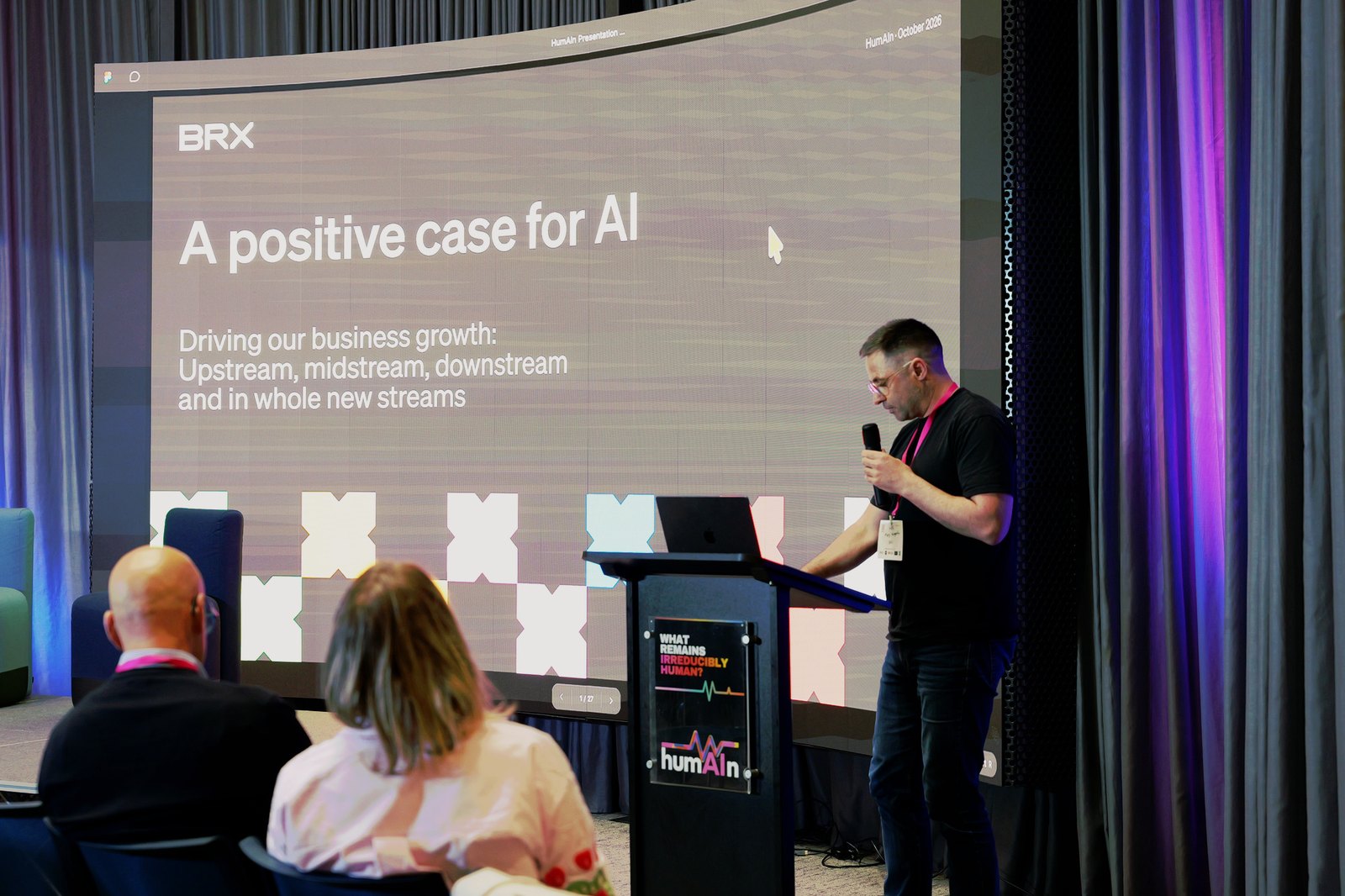 A man speaking at the lectern in front of a BRX slide titled "A positive case for AI"