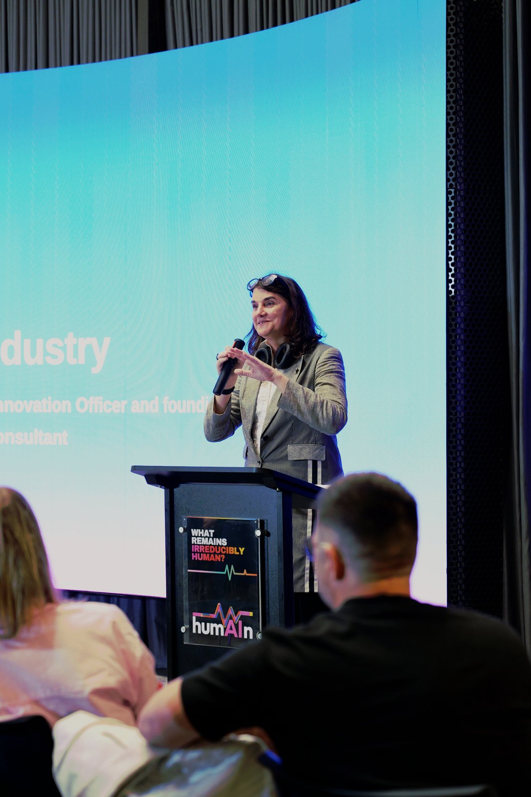A woman speaking with a microphone at the lectern